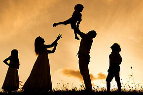 Photo d'une famille en train de jouer en plein air