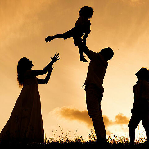 Photo d'une famille en train de jouer en plein air